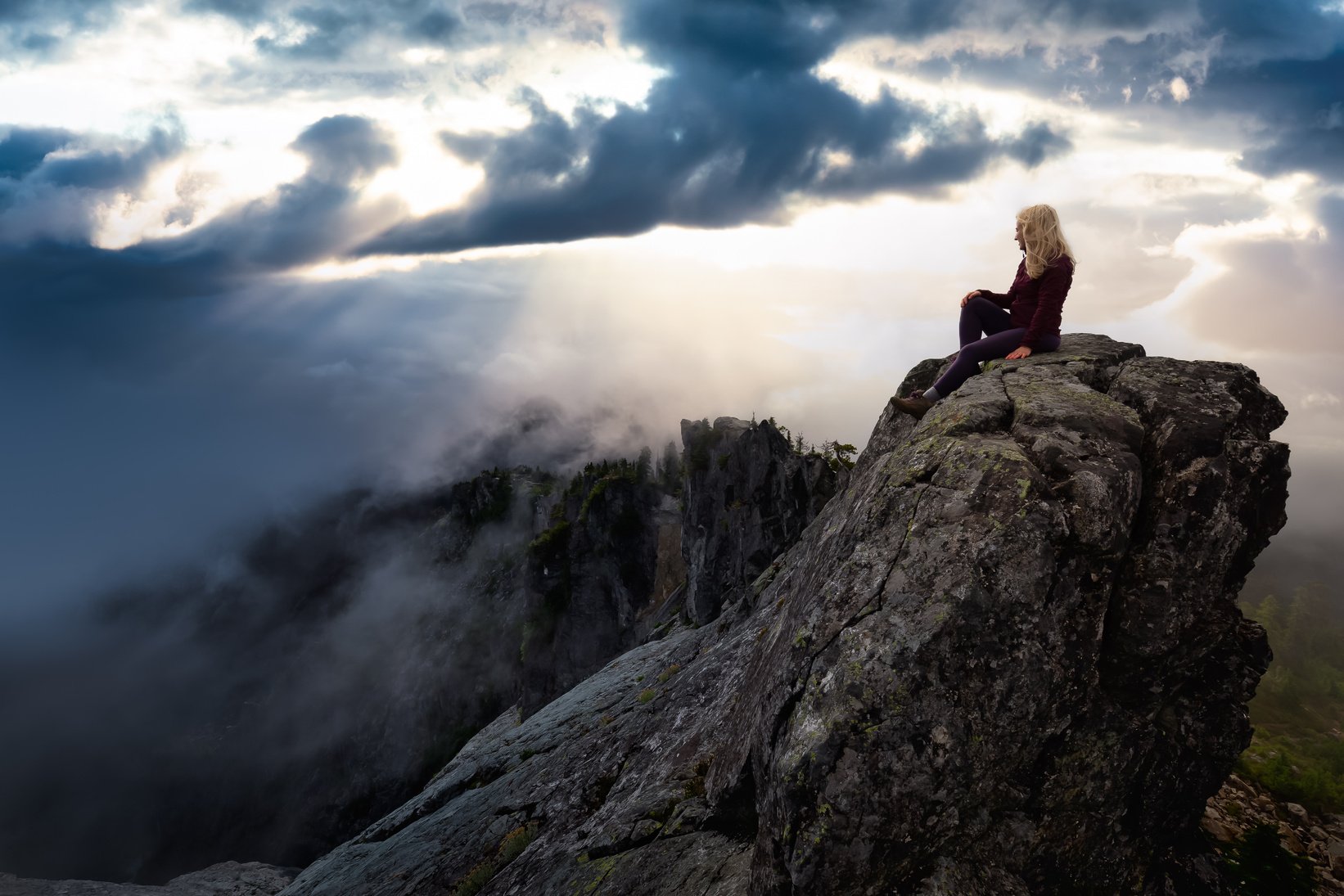 Woman Sitting on a Mountain Peak