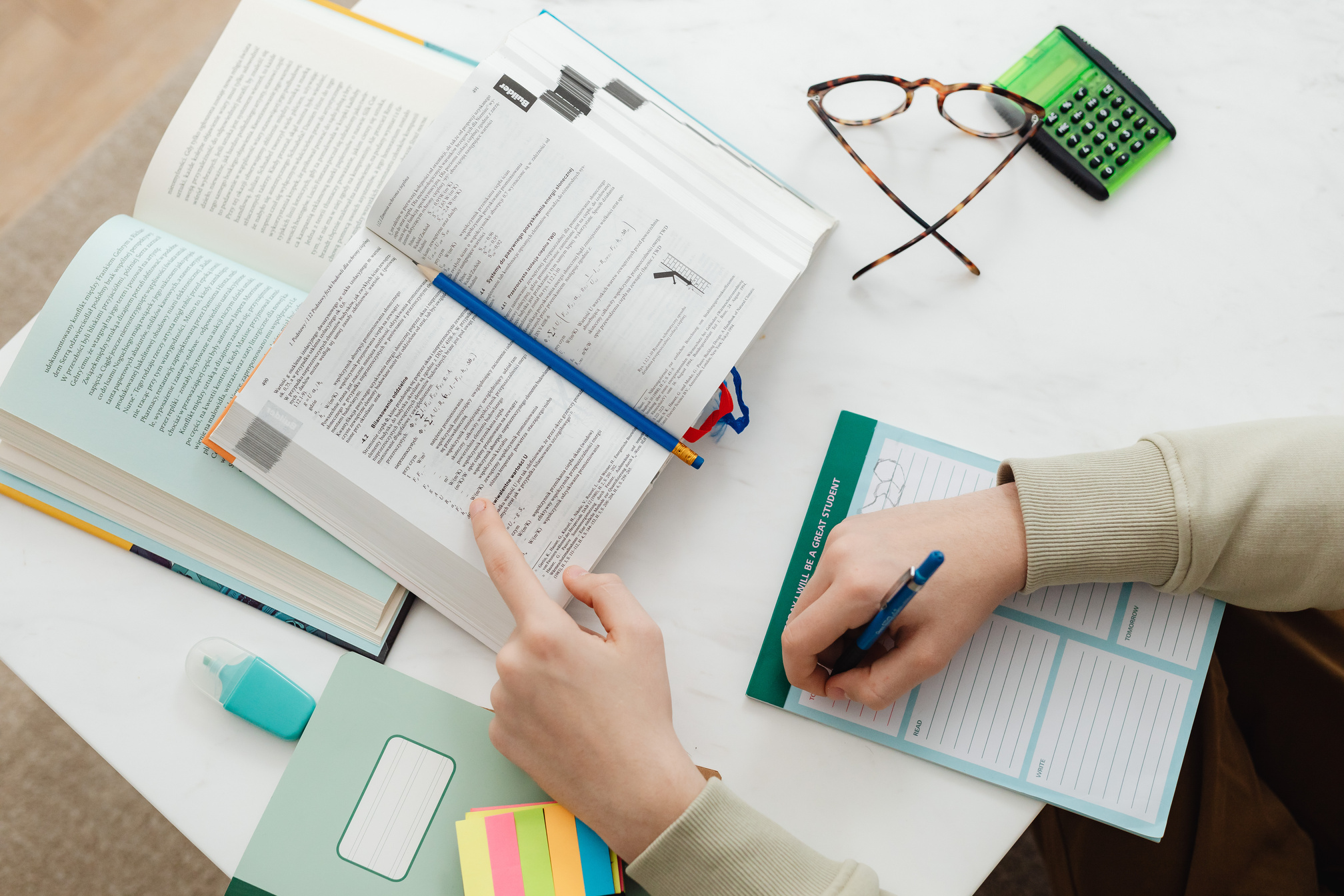 Person Studying And Writing Notes On Paper